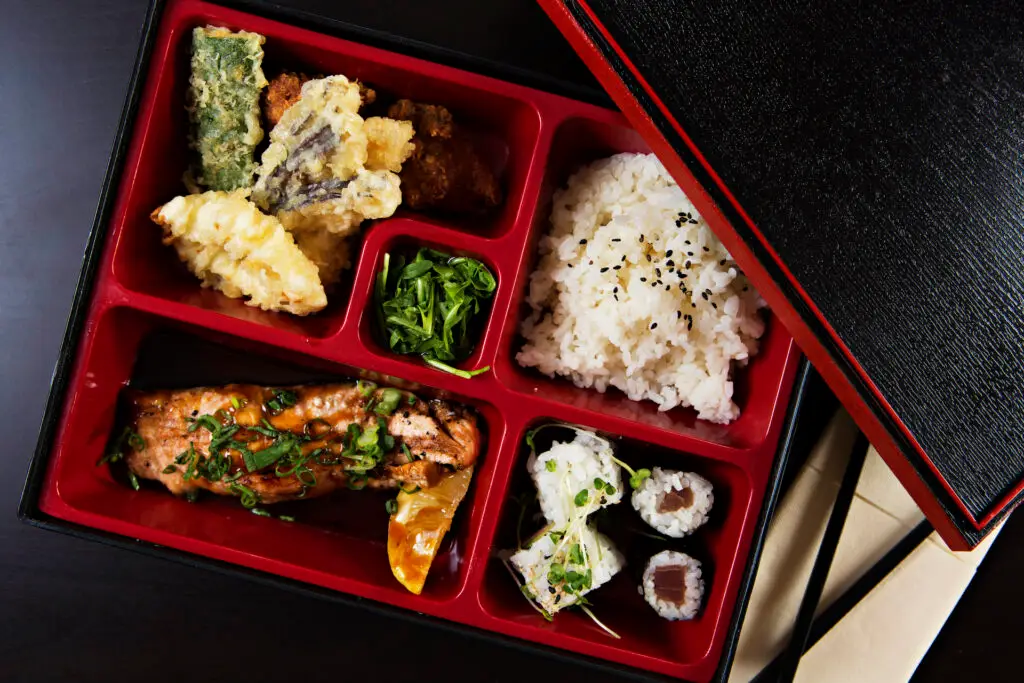 traditional Japanese food in a black and red bento box